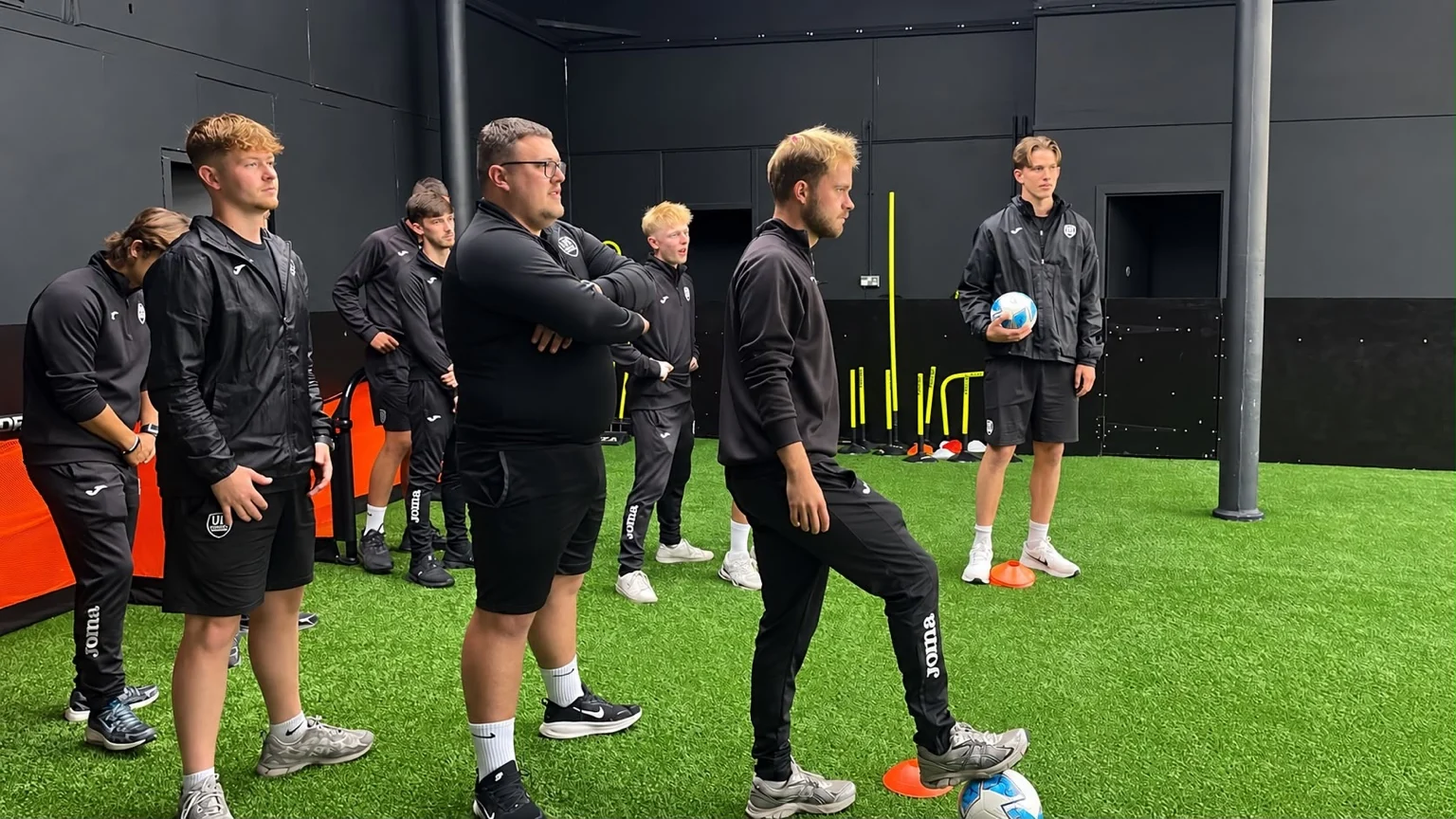 UK Sports coaches taking part in a practical football coaching activity with cones and a ball